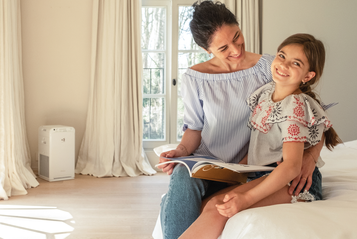 Woman in living room enjoying clean air thanks to an air purifier