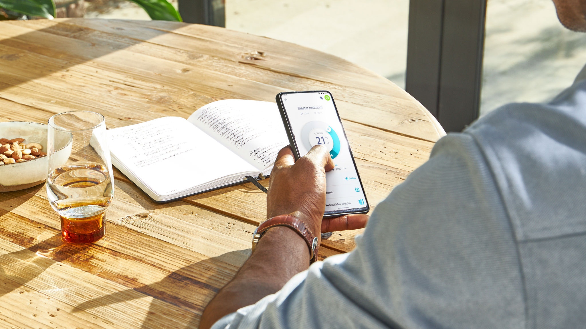 Un hombre controlando la temperatura de su casa desde cualquier lugar con la app Daikin Onecta en su smartphone