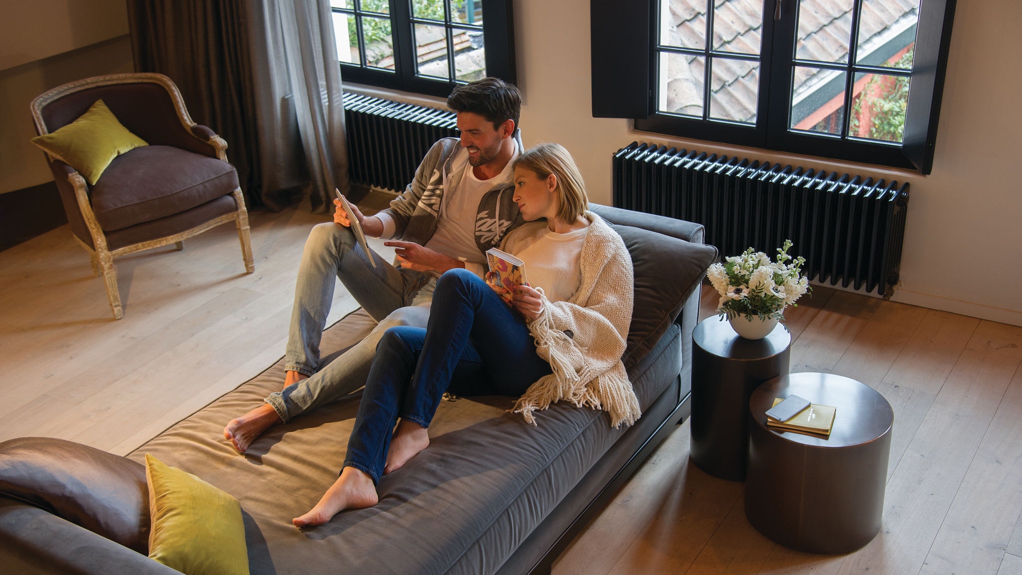 Pareja relajándose en un sofá y mirando algo en su tablet
