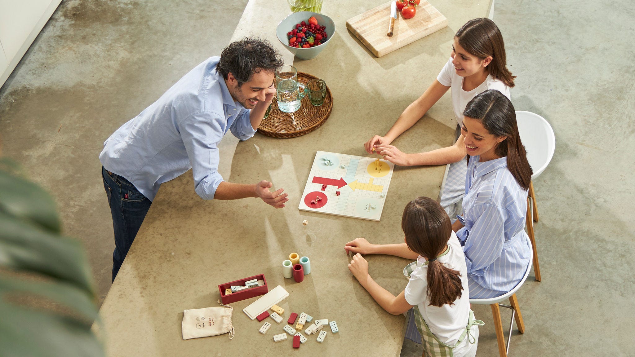 Familia con dos niños jugando a un juego en la mesa de la cocina de su casa energéticamente neutra.