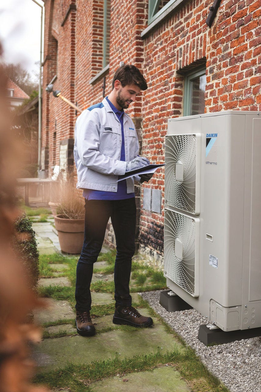 Un hombre instalando una unidad exterior