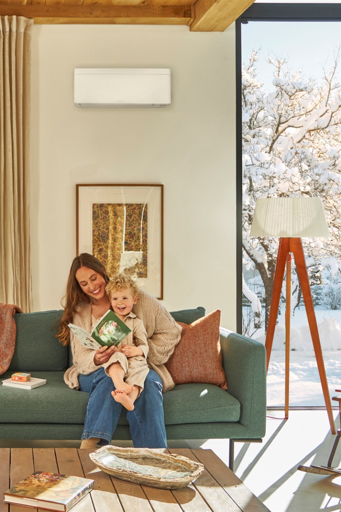 Mother and child reading a book on the couch in comfortable temperature