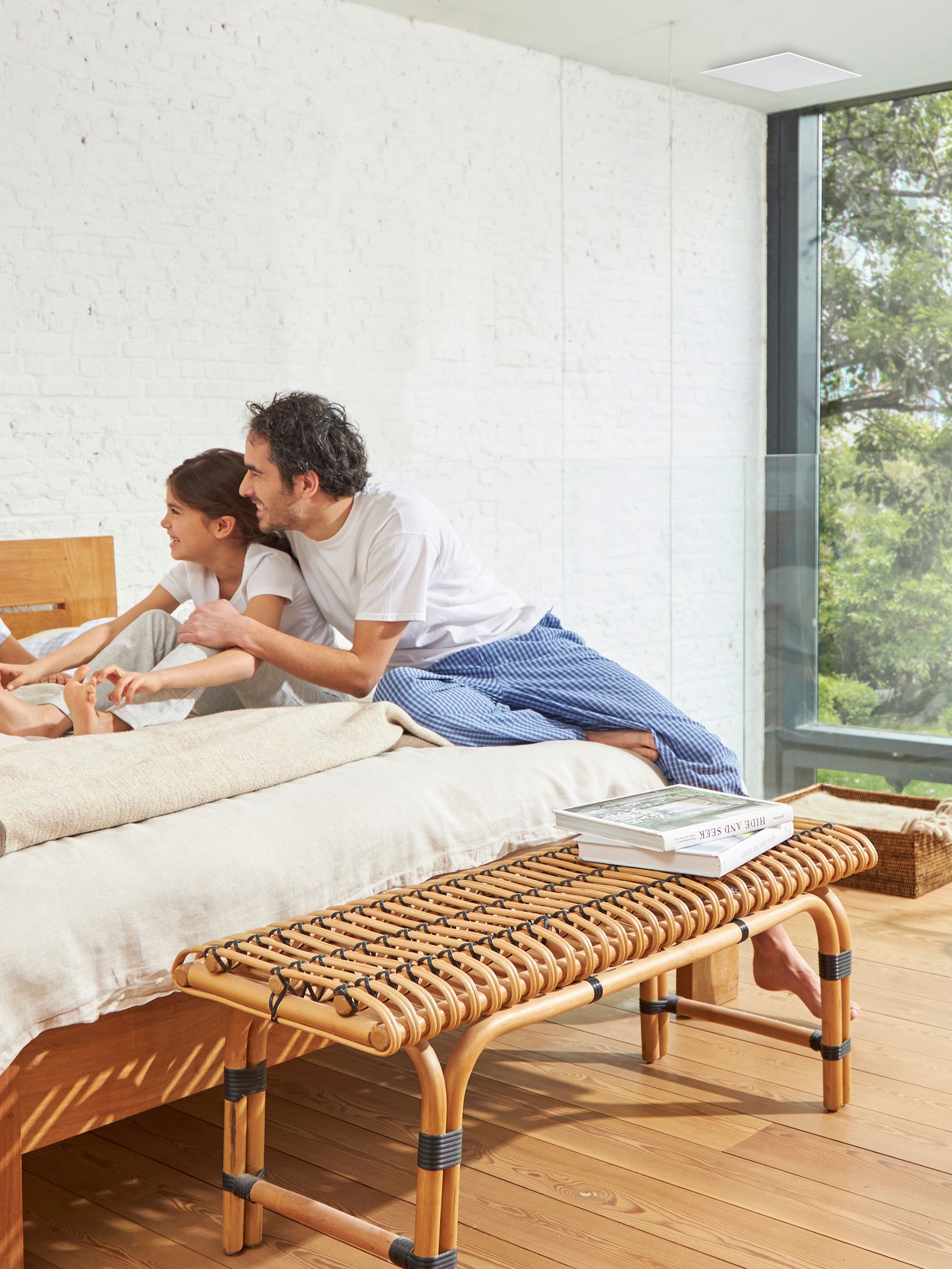 Padre e hija en una cama en una habitación bien ventilada