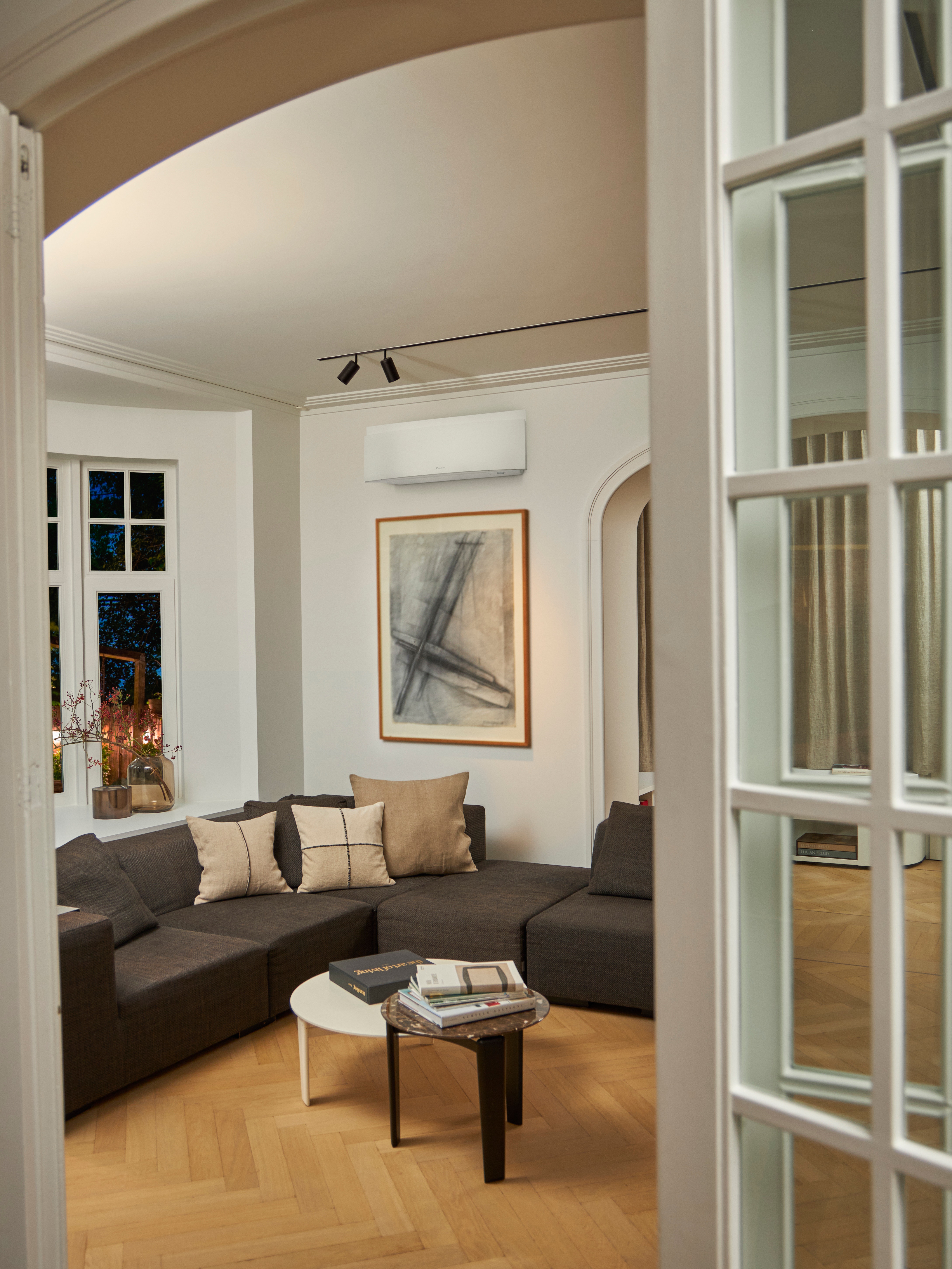 Sala de estar con sofá y solución de climatización de pared encima